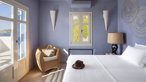 Une chambre à coucher avec un lit, une chaise, une lampe et une fenêtre donnant sur un paysage verdoyant.