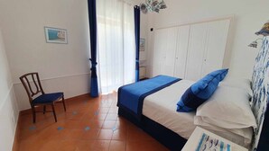 Une chambre à coucher avec un lit, une chaise, une armoire et une fenêtre avec des rideaux.