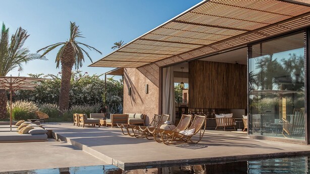 A modern outdoor pool area with lounge chairs and a pergola.