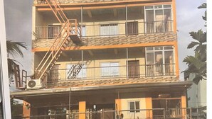 A multi-story building with a fire escape, balconies, and a gated entrance. - Feel like home one bedroom studio 
full kitchen, Near Satisima Trinidad Church (Malolos)
