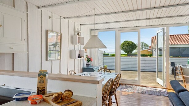 A modern kitchen with wooden countertops, a cutting board with bread, and a box of Muni yogurt. - "Hira" - 200m from the sea by Interhome (Egernsund)