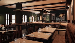 Interior de restaurante con mesas y sillas de madera, iluminación colgante y una zona de bar.
