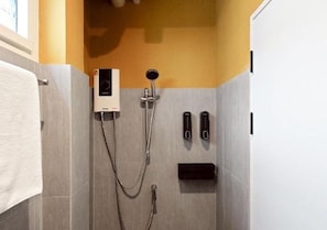 A shower area with a handheld showerhead, a wall-mounted control panel, and a towel rack. - Au Luna Bangkok Hostel (Bangkok)