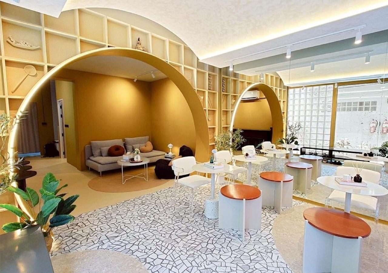 A modern interior with a sofa set, round tables, and a patterned floor.