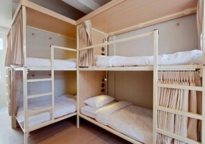 A bunk bed room with three levels, each with a mattress and pillows. - Au Luna Bangkok Hostel (Bangkok)