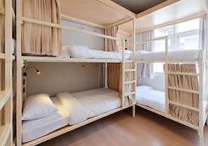 A bunk bed room with a wooden floor, a night light, and curtains. - Au Luna Bangkok Hostel (Bangkok)