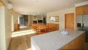 A spacious kitchen with a granite countertop, wooden cabinets, and a stainless steel refrigerator. - Bela Vista Villa with pool for 12 persons (Gerês)