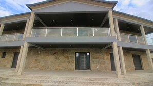 A two-story building with a stone facade, a central entrance, and a balcony on the upper floor. - Bela Vista Villa with pool for 12 persons (Gerês)