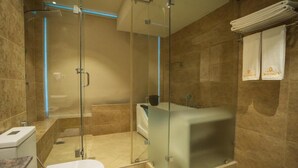 A modern bathroom with a glass-enclosed shower, a glass-enclosed bathtub, and a white toilet.