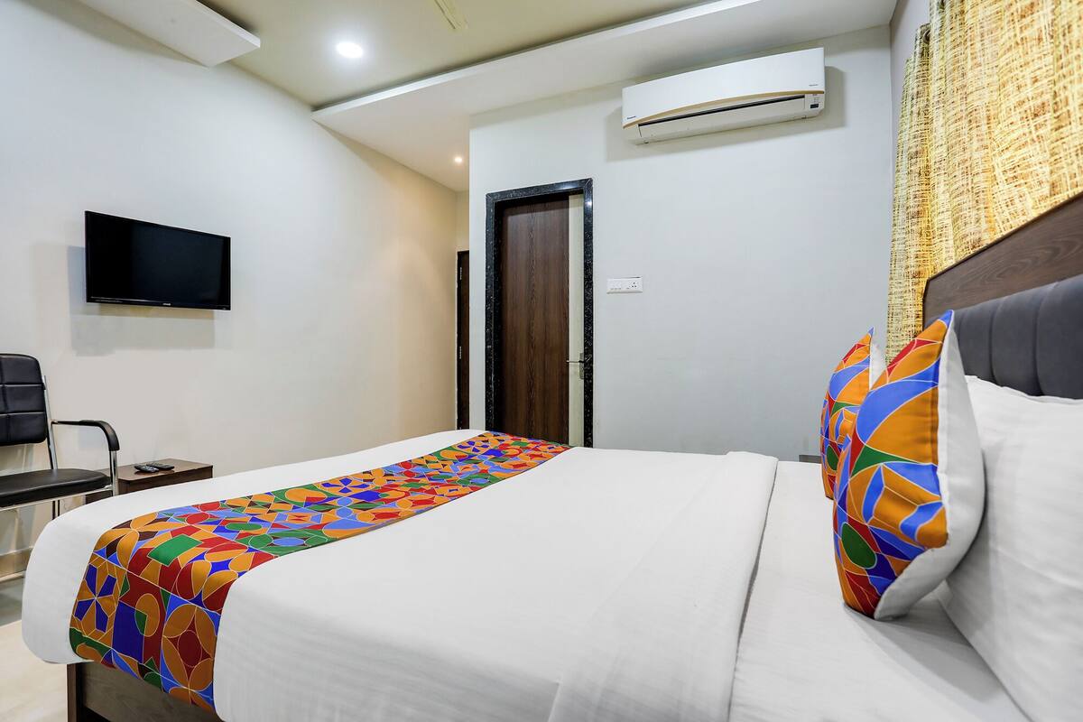 Une chambre d’hôtel équipée d’un lit, d’une télévision, d’un climatiseur et d’une porte.