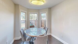 A dining area with a round table, four chairs, and three windows. - Charming 3-Bedroom Home in Prime Frisco Location Fast WiFi & AC (Frisco)