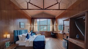A wooden-paneled bedroom with a bed, desk, and wardrobe. - Clarion Hotel De Renees Gangtok ( 5km from MG Marg) (Gangtok)