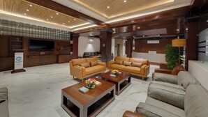 A spacious lobby with leather sofas, a coffee table, and a television. - Clarion Hotel De Renees Gangtok ( 5km from MG Marg) (Gangtok)