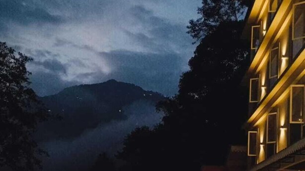 A swimming pool with a view of mountains at dusk. - Clarion Hotel De Renees Gangtok ( 5km from MG Marg) (Gangtok)