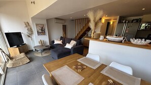 A modern living room with a dining area, a TV, and a kitchen in the background. - Holiday home 100m from the beach for 4 people (La Croix-Valmer)
