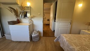 A bedroom with a bed, a dresser, a mirror, and a doorway leading to another room. - Holiday home 100m from the beach for 4 people (La Croix-Valmer)