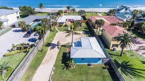 Zona residencial costera con casas, piscina y playa.