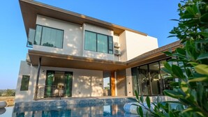 A modern two-story house with a swimming pool in the foreground. - Six elements pool villa khaokho (Khao Kho)