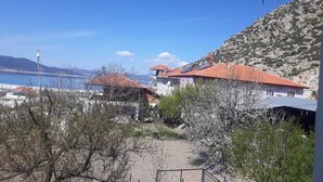 A coastal village with terracotta-roofed houses, a clear blue sky, and a view of the sea. - Tan Apart Aile Ev Pansiyonu (Yesilova)
