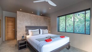 A modern bedroom with a large bed, bedside tables, a ceiling fan, and a window with blinds. - Elegant 4-bedroom villa with private pool, waterfall showers, and garden (Tambon Mae Nam)