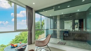 Une pièce moderne dotée d’une grande fenêtre, d’un coin repas avec une table et des chaises, et d’un espace cuisine avec un dosseret carrelé.