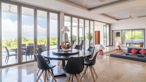 Une pièce spacieuse avec une grande table à manger entourée de chaises, d’un canapé et d’un ventilateur de plafond.