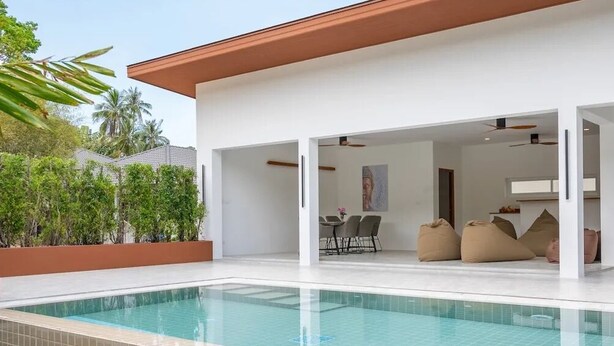 A modern house with a swimming pool, an open-plan living area, and a dining space.