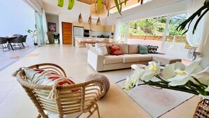 Ein modernes Wohnzimmer mit einer Couch, Sesseln und einem Essbereich.