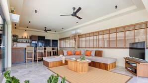 A modern living room with a sofa, coffee table, and TV stand. - Stunning 3-bedroom villa in Chaweng with private pool and sea views, near beach (Koh Samui)