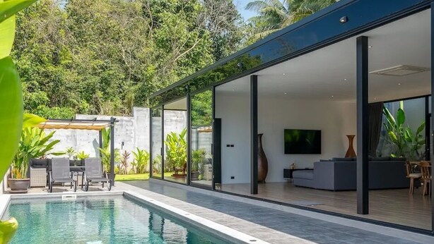 A modern house with a swimming pool, glass doors, and a flat-screen TV. - Modern 2-bedroom oasis with private pool, garden, and dedicated workspace, ideal for families (Tambon Mae Nam)