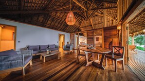 Una habitación amplia con techo de madera, un sofá, una mesa de comedor y una silla.