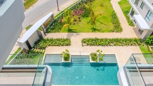 Une piscine sur le toit offrant une vue dégagée sur la végétation environnante et les bâtiments adjacents.
