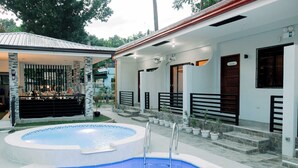 A swimming pool with a covered area, steps leading to a door, and potted plants. - Micasa Mabini (Puerto Princesa)