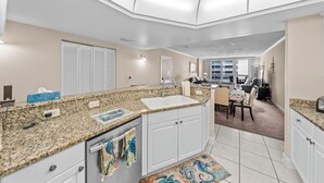 A modern kitchen with granite countertops, white cabinetry, and a central island.