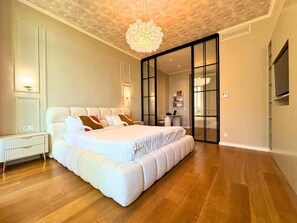 Un dormitorio con una cama grande, un radiador y un diseño moderno en el techo.