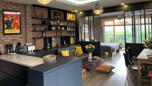 A modern kitchen with a brick wall, a central island, and a dining area with a table and chairs. - Hanoi city center, apartment with all the comforts to visit the city (Hà Nội)