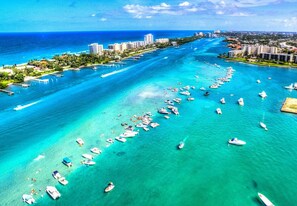 An aerial view of a coastal area with numerous boats, a marina, and buildings along the shore. - Tranquility Villa: Heated Pool & Lanai (Jupiter)