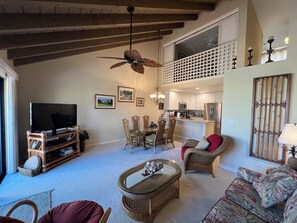 Amplia sala de estar con televisor, comedor y cocina.
