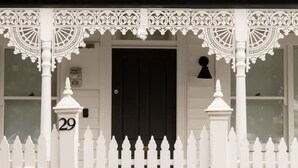 A white house with a black door, a white picket fence, and a number 29 sign. - Seddon Smart Home with Private Pool Getaway (Seddon)