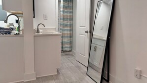 Een badkamer met een wastafel, spiegel en douchegordijn.