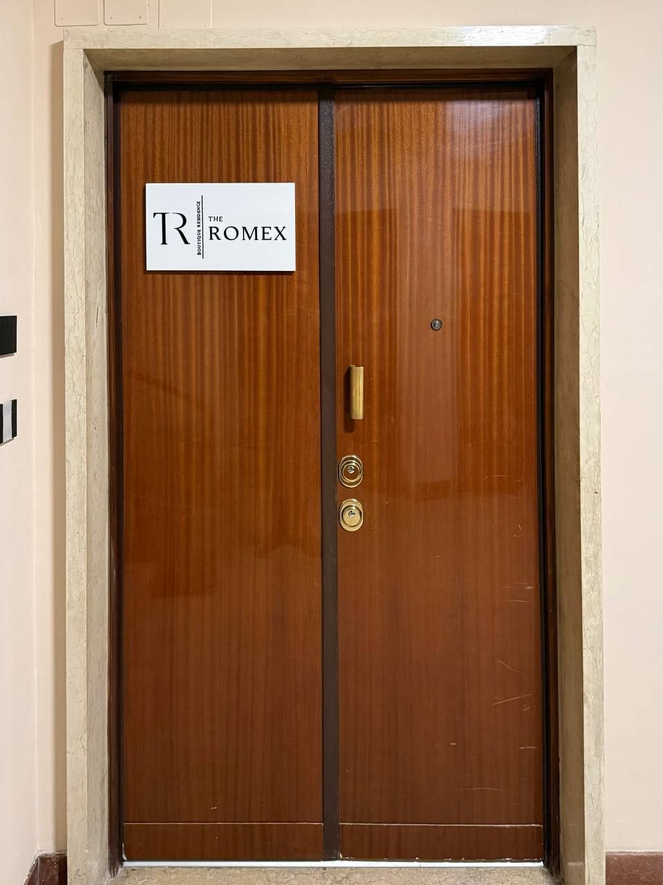 Una puerta doble de madera con un letrero que dice "ROMEX".