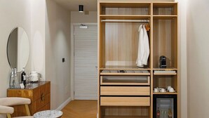 A modern bathroom with a wooden vanity, a mirror, and a small table. - The Romex (Rome)