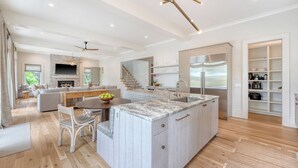 Una cocina moderna con una isla grande, electrodomésticos integrados y un comedor con chimenea.