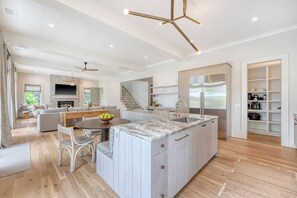 A modern kitchen with a large island, built-in appliances, and a dining area with a fireplace.