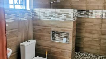 Chuveiro, toalhas de banho, papel higiênico