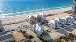 A coastal hotel with multiple buildings, a beach, and a clear view of the ocean.