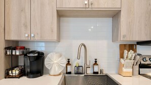 A modern kitchen with a stainless steel sink, a coffee machine, and a knife block. - 1b1b Cozy Unit in Ravenna close to U District (Seattle)
