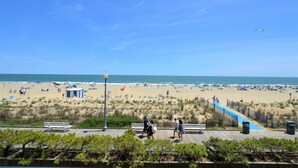 A beach with a wooden boardwalk, benches, and a clear blue sky. - Edgewater House - Ocean Front Units With Spectacular Views! (Rehoboth Beach)