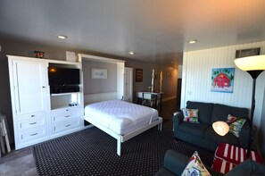 Een hotelkamer met een bed, een bureau, een bank en een televisie.