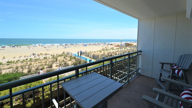 A balcony with a view of a beach, a pool, and beach chairs. - Edgewater House - Ocean Front Units With Spectacular Views! (Rehoboth Beach)